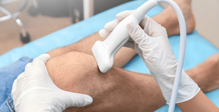 A professional conducting a musculoskeletal ultrasound on a patient's knee, utilizing a handheld transducer to capture detailed images of the soft tissues, demonstrating the non-invasive diagnostic process in a clinical setting.